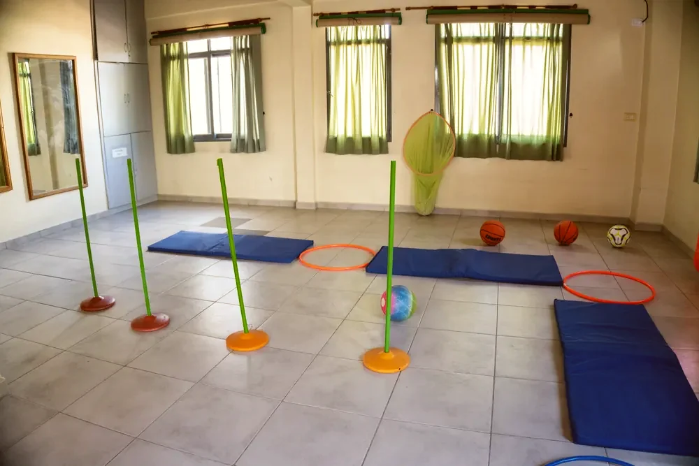 Gimnasio con colchonetas, aros y pelotas para educación física
