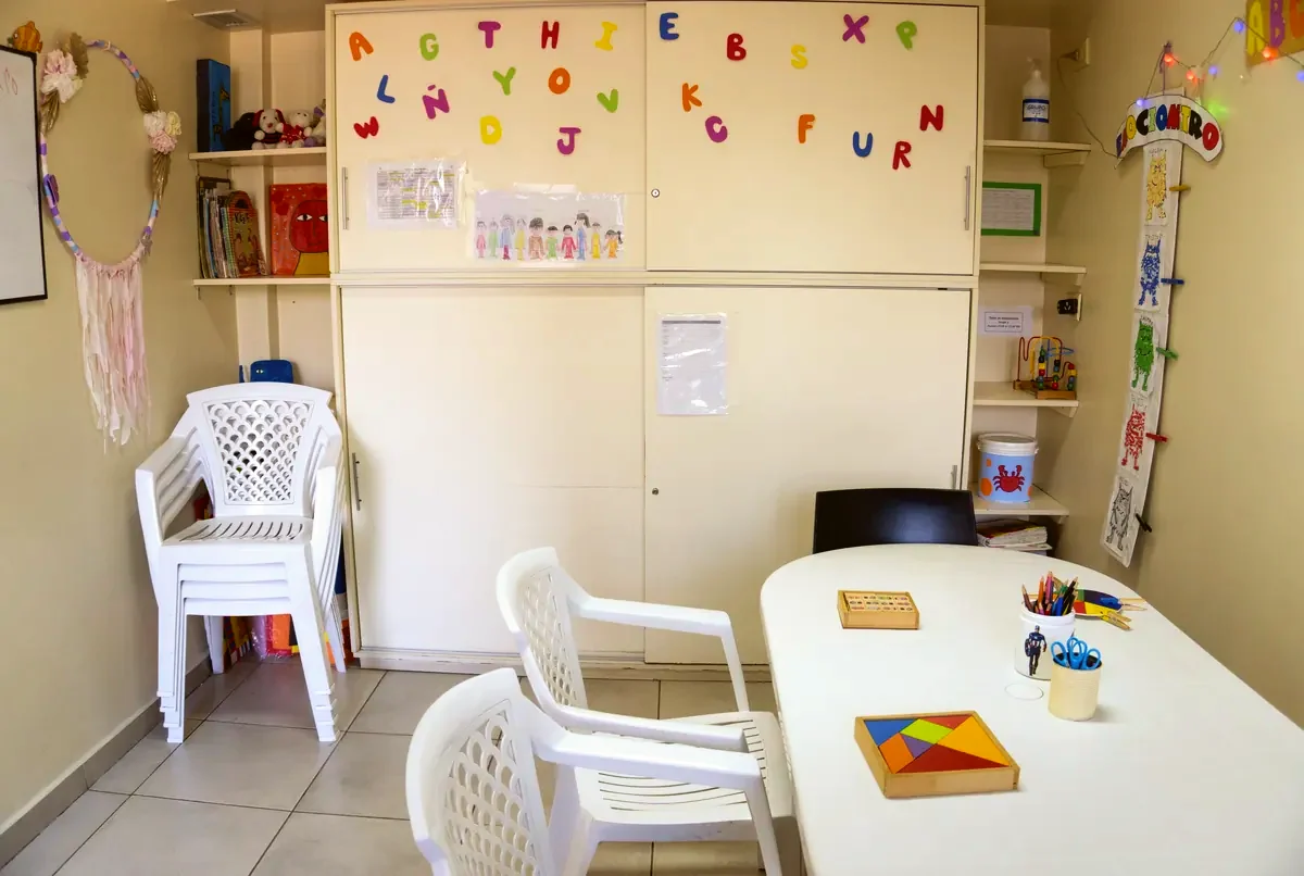 Sala de trabajo del centro con mesa, sillas y materiales
